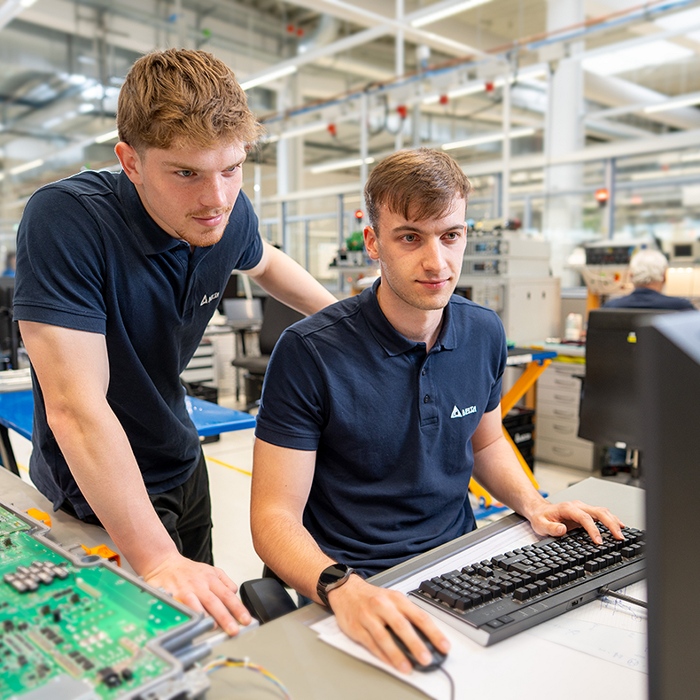 Zwei Studenten in der Entwicklung schauen auf einen Computer