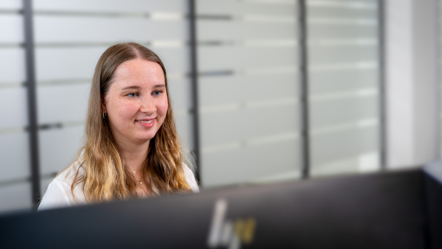 Junge Studentin arbeitet am Computer in einem Büro