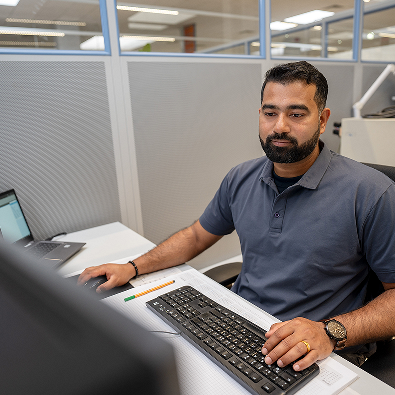 An Indian employee is working at a computer