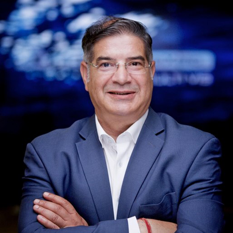Dalip Sharma A middle-aged man with glasses is wearing a blue suit with a white shirt